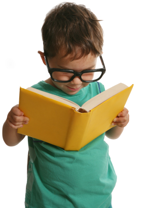 Boy with over-size glasses reading a book.