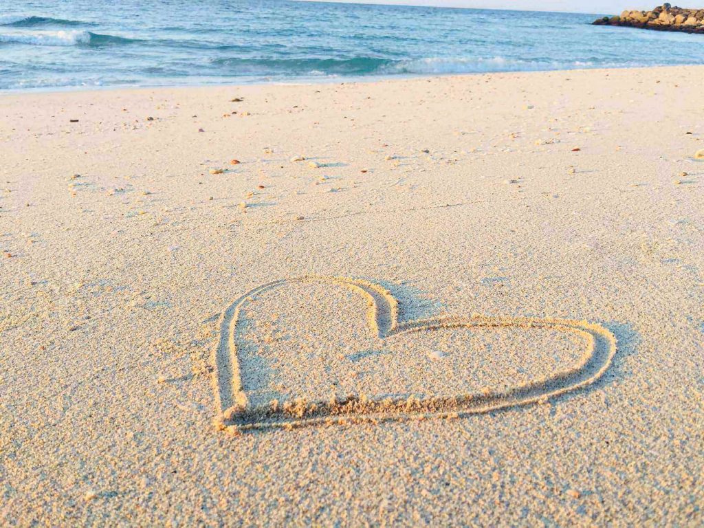Heart traced in the sand on the beach.