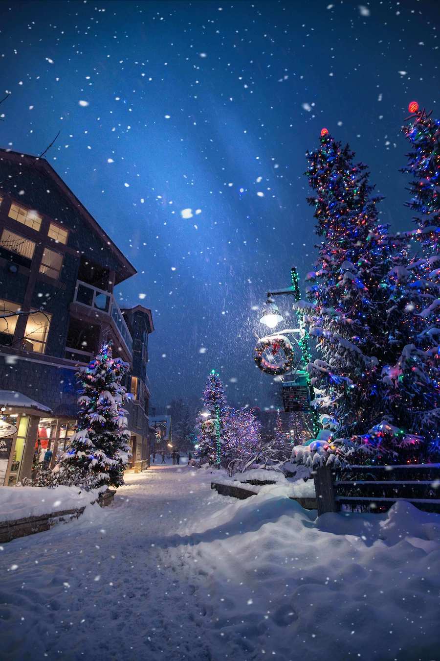 night time scene with holiday lights and snowy street